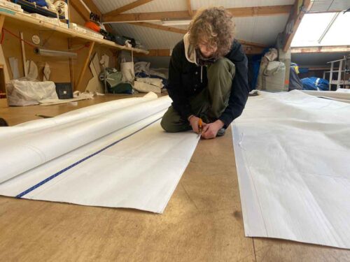 Travaux de finition sur une voile de bateau réalisés par un professionnel