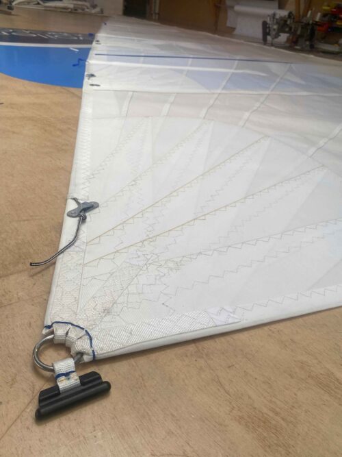 Voile blanche déployée dans notre atelier de voilerie à Cherbourg