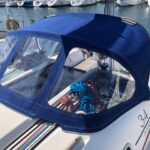 Capote bleue sur mesure installée sur un voilier pour protéger le cockpit
